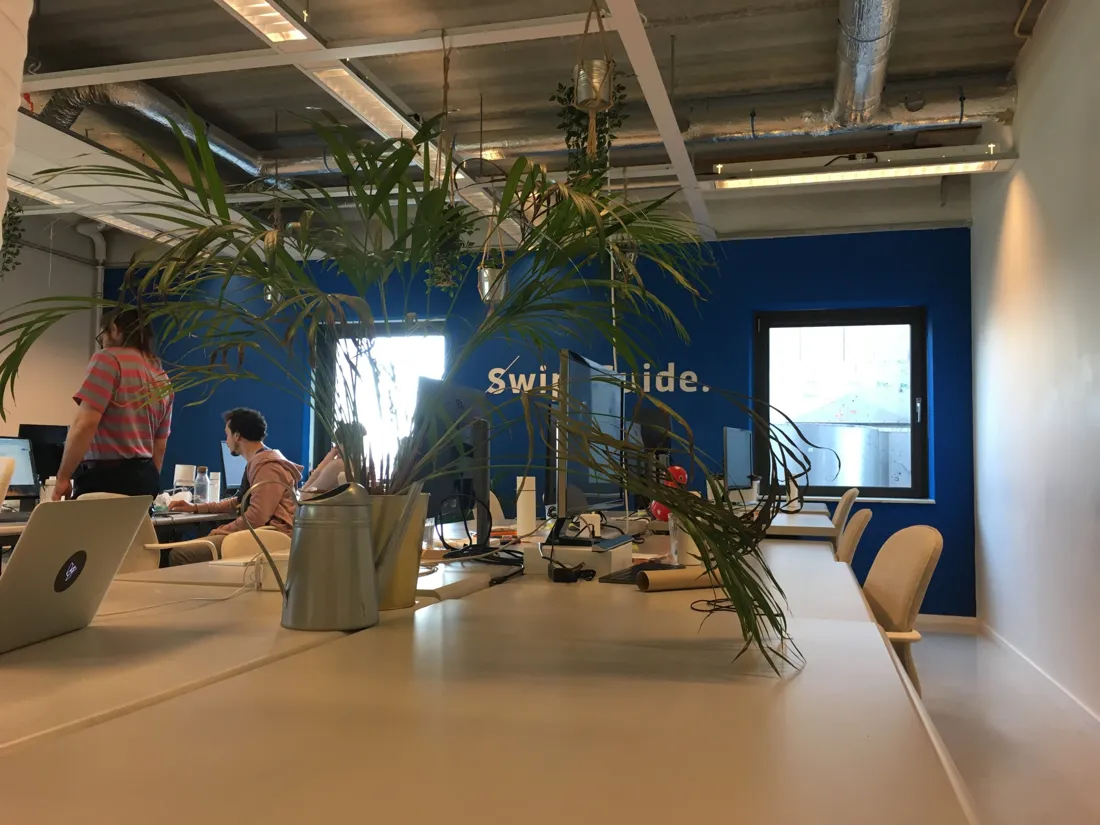The SwipeGuide office with its blue logo wall